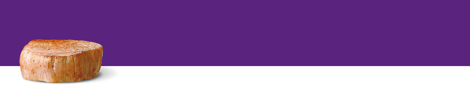 A cylindrical wooden object stands against a purple background.