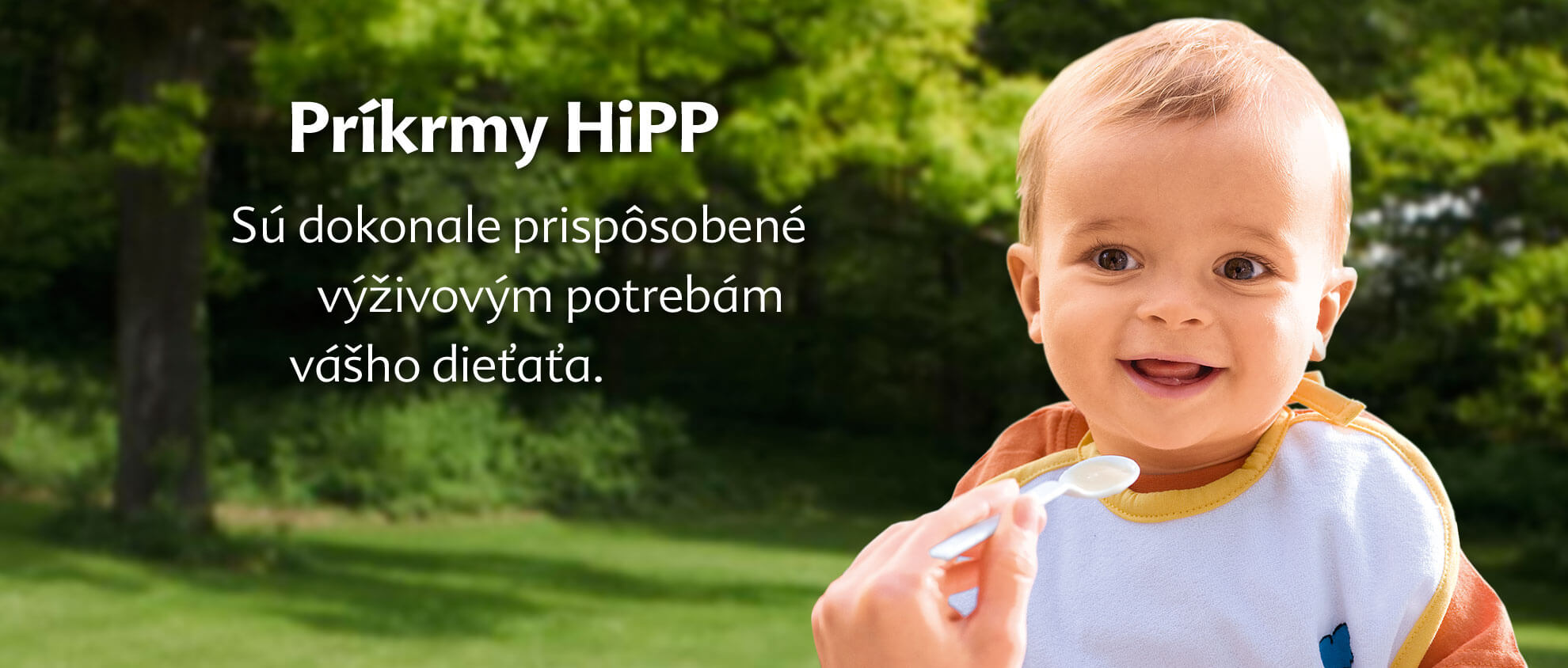 Dieťa je kŕmené lyžičkou vonku a text je v cudzom jazyku.