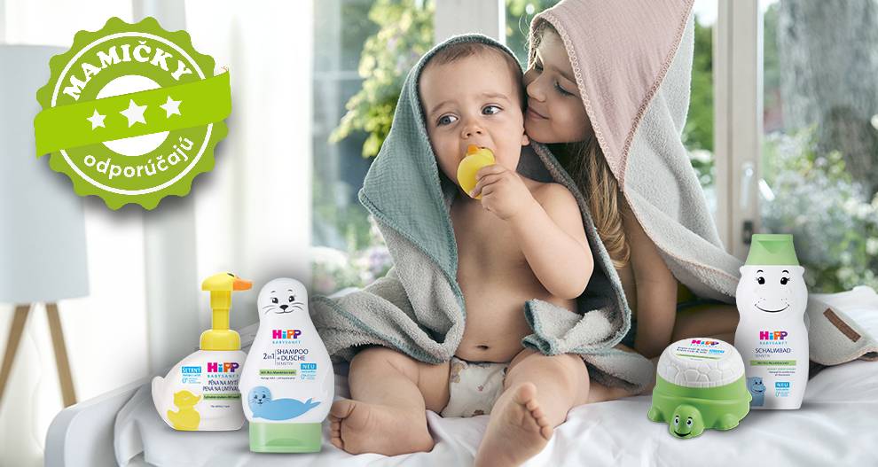 Dieťa je zabalené v uteráku, obklopené výrobkami na starostlivosť o dieťa, so zeleným odznakom v pozadí.