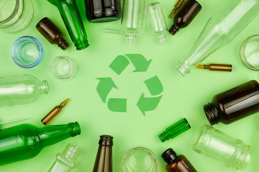 Rôzne nádoby na sklo sú usporiadané okolo zeleného symbolu recyklácie.
