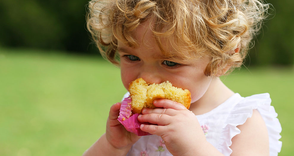 Dieťa s kučeravými vlasmi je žltý muffin.