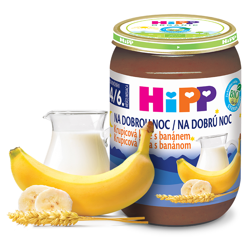 Pohár detskej výživy Hipp s banánovou príchuťou spolu s džbánom mlieka a banánom.
